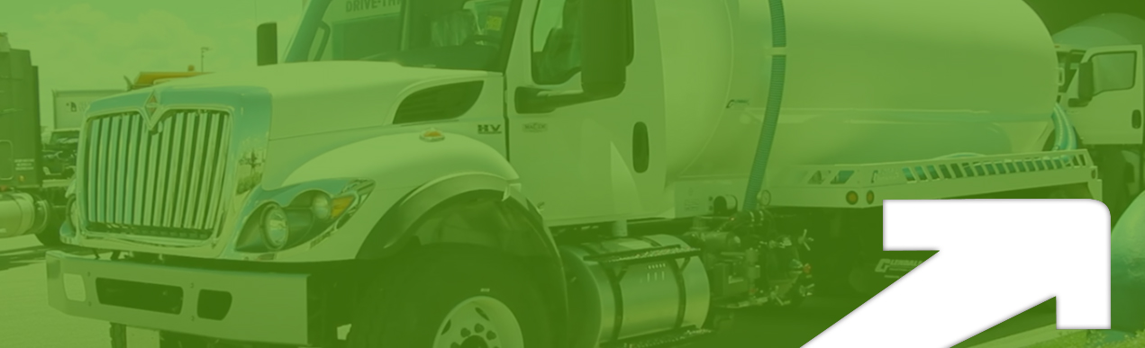 Photo of a septic truck under a green opaque layer with a white arrow in the bottom left