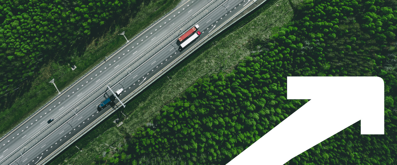 truck driving on a road with a white arrow in the corner